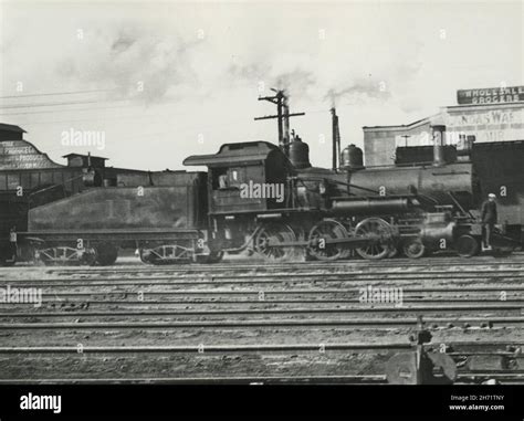 Grayscale Of A Steamed Locomotive In 19th Century Railroad Stock Photo