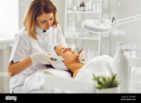 Young Cosmetologist Or Dermatologist Making Ultrasound Facial Cleaning