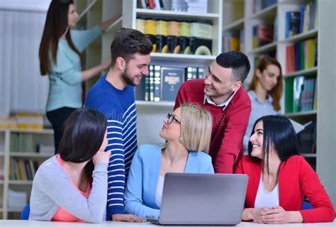 Group Of Students Working Together In Library With Teacher Stock Photo