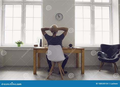 Back View Man Hands Behind His Head Dreams Of Resting While Sitting On