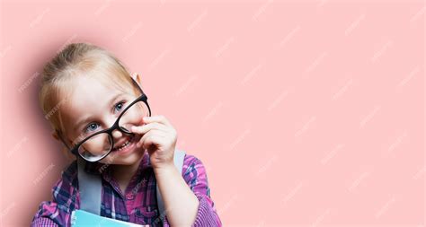 Premium Photo Cute Little Blonde Girl In Glasses With A Backpack On A Pink Walll Teaching
