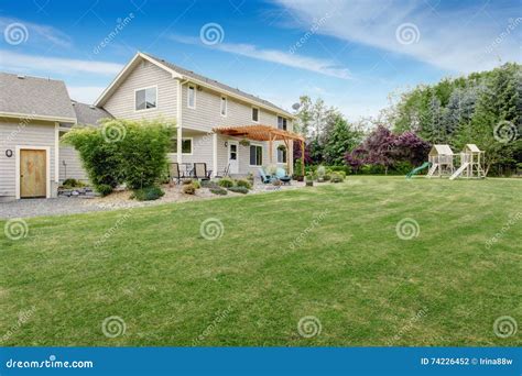 Beautiful House Backyard With Well Kept Lawn And Patio Area Stock Photo