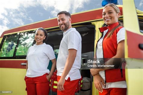 photo libre de droit de trois ambulanciers paramédicaux multiraciaux debout devant un véhicule
