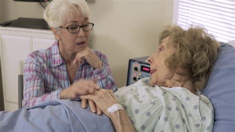 Woman Visiting Her Sick Elderly Friend In The Hospital Stock Video