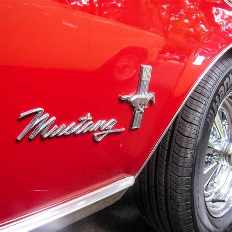 The Front End Of A Red Classic Car With Chrome Lettering On It S Side