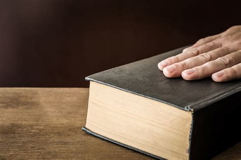 Mans Hand Swearing On The Bible Taking An Oath Stock Photo Download