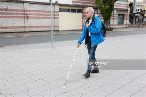 Blind Man Walking In Street Supported By Cane High Res Stock Photo