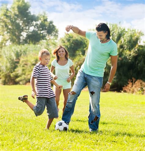 Familia Feliz De Tres Jugando Con La Pelota Foto Gratis