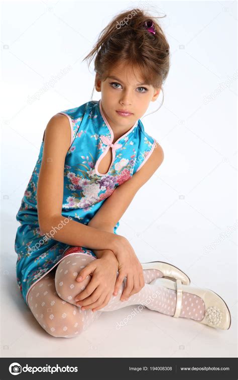 アジアの青いドレスの美しい少女は 白い背景に座っています スレンダーな身体と白ストッキングの長い脚を持つエレガントな魅力的な子 若いモデル ファッション スタイルで — ストック写真 ©