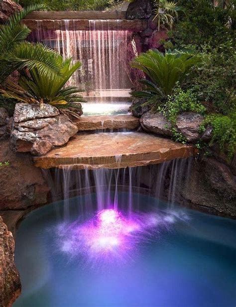 A Small Waterfall In The Middle Of A Pool Surrounded By Rocks And