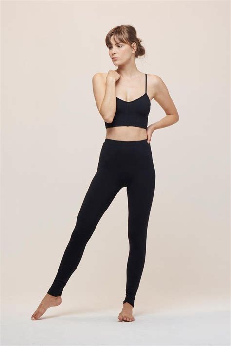 A Woman In Black Sports Bra Top And Leggings With Her Hand On Her Hip