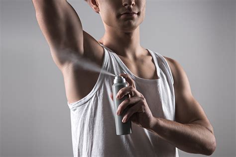 유토이미지 partial view of babe man in white sleeveless shirt spraying deodorant on underarm