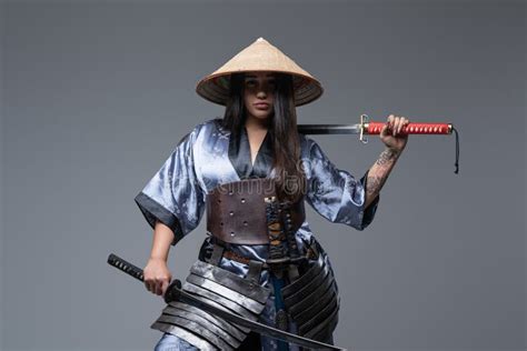 Young Female Warrior With Samurai Swords And Bamboo Hat Stock Image