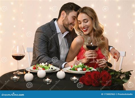 Passionate Couple Dining In Restaurant Drinking Wine And Having