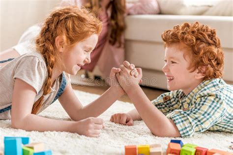 Side View Of Brother And Sister Playing Arm Wrestling Stock Photo