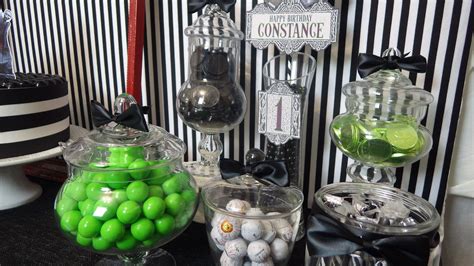 There Are Many Candies In Glass Containers On The Table With Black And
