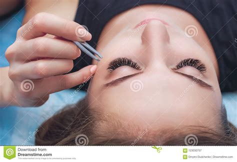 The Make Up Artist Plucks Her Eyebrows From A Young Woman In A Beauty