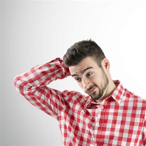 Portrait Of Confused Young Bearded Man Looking Down Stock Photo