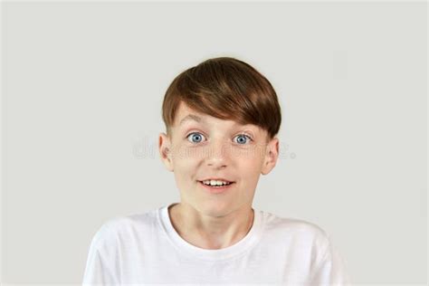 A Boy With His Eyes Wide Open Looks Scared At The Camera Stock Photo