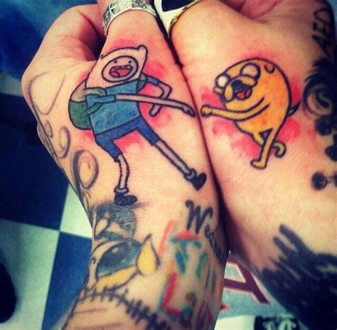 Two People With Tattoos On Their Hands Holding Each Other