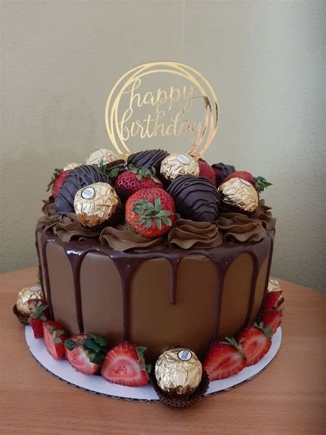 A Chocolate Covered Cake With Strawberries And Chocolate Frosting On