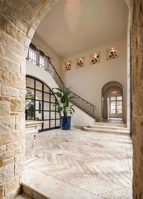 A Large Foyer With Stone Steps And An Arched Doorway Leading To The