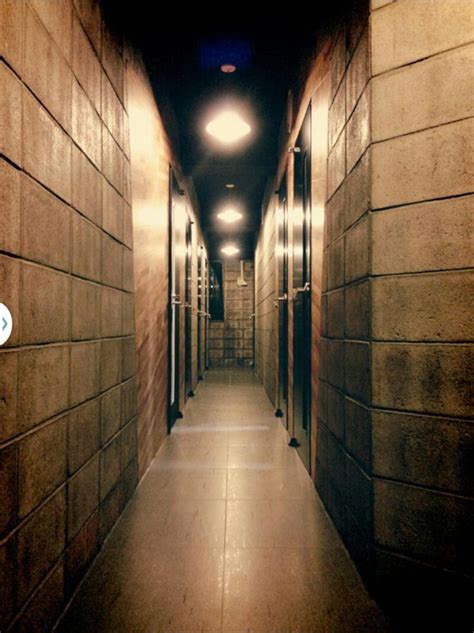 a long hallway with several doors and lights on either side of the corridor leading to another room