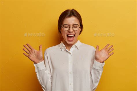 Sincere Emotions And Feelings Concept Overjoyed Caucasian Woman Raises Palms Laughs Out