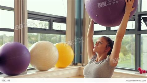 Sporty Brunette Woman Lifting Exercise Ball Stock Video Footage