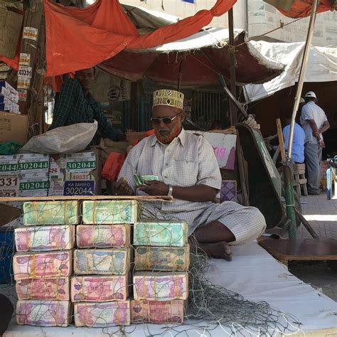 Somaliland A Money Changer Counts Notes In His Stall At A Bureau De