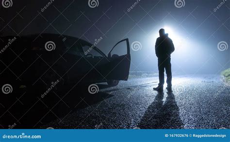 A Man Standing Next To A Car With Door Open Parked On The Side Of The