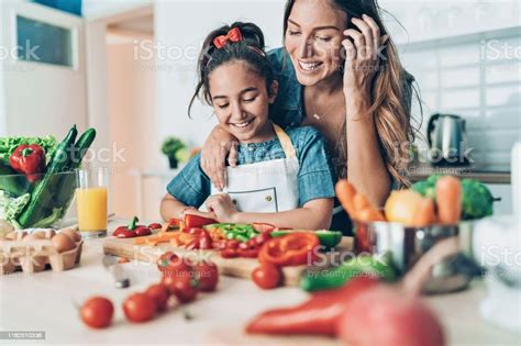 Mother Teaching Her Daughter To Cook Stock Photo Download Image Now