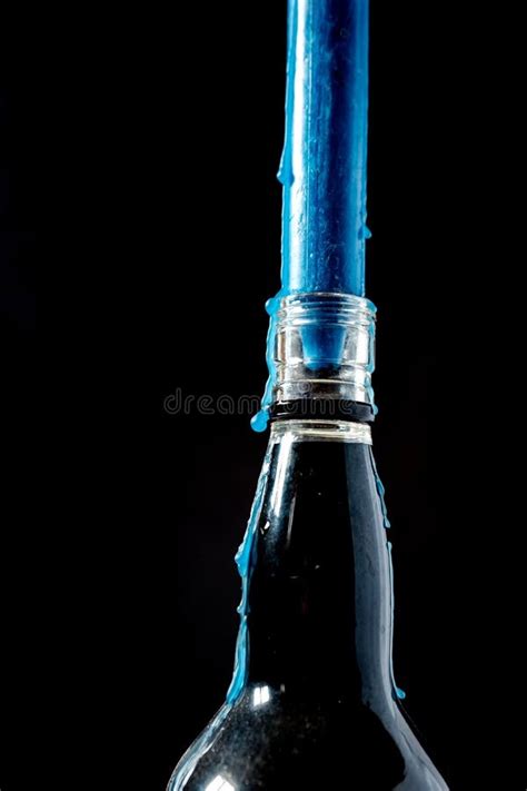 Vertical Closeup Shot Of A Single Candle In A Glass Bottle With A Melted Wax Drips Stock Photo