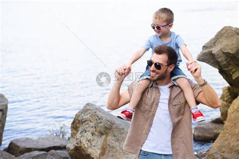 父亲微笑地抱着儿子在肩膀上高清图片下载 正版图片502702647 摄图网