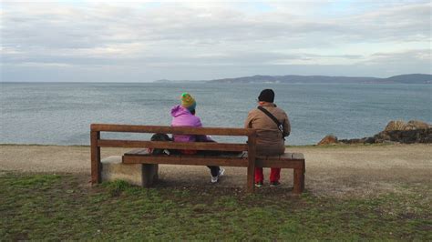 Two People Sitting On A Bench Watching The Sea Free Stock Video