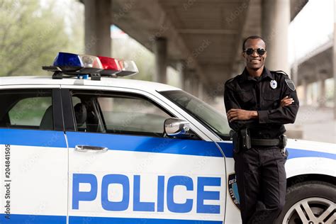 Handsome African American Police Officer With Crossed Arms Leaning Back