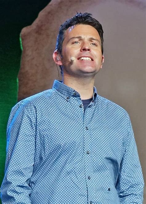 a man standing in front of a green screen with his hands on his hips and smiling