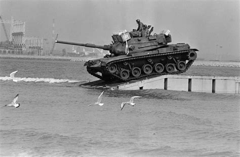 An M60 Main Battle Tank Comes Ashore From A Floating Causeway During
