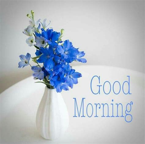 A White Vase Filled With Blue Flowers And The Words Good Morning