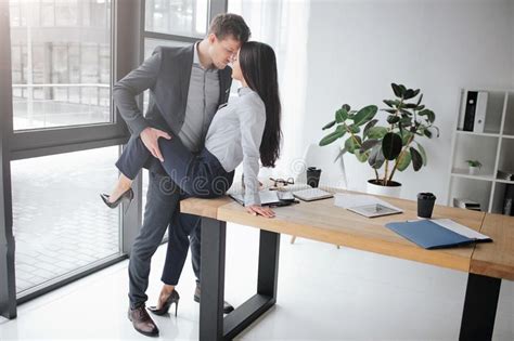 image sexuelle et intime des couples au travail elle s asseyent sur la table il tiennent sa