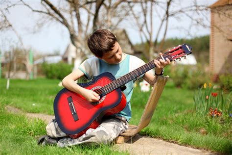 Boy Playing The Guitar Outdoors Stock Photo Image Of Caucasian