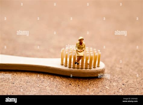 Miniature Figurine Sitting On A Bamboo Toothbrush Ecological