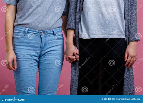 twee lesbiennes houden handenclose up op een roze achtergrond stock afbeelding image of