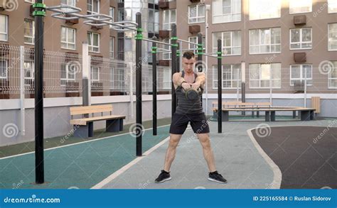 A Young Man Lunges With Kettlebells A Man Lifts A Kettlebell While