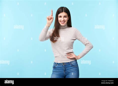 Studio Portrait Of A Beautful Caucasian Woman Finger Pointing Upward