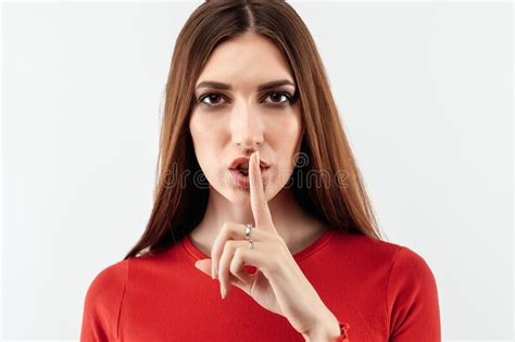 Portrait Of A Pretty Young Woman Holding Index Finger On Lips Silence And Secret Concept