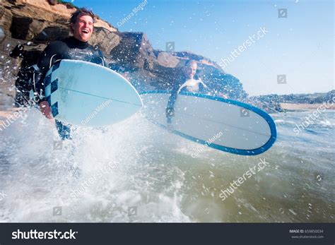 Two Men Running Into Water Surf Stock Photo 659850034 Shutterstock