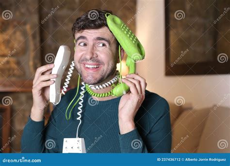 Messy Man Using Two Landline Telephones At The Same Time Stock Photo