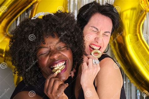 Two Multiracial Women In A 40 Birthday Party Biting 40 Birthday Golden Candles Stock Image