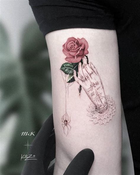 Hand Holding Rose Tattoo On The Upper Arm